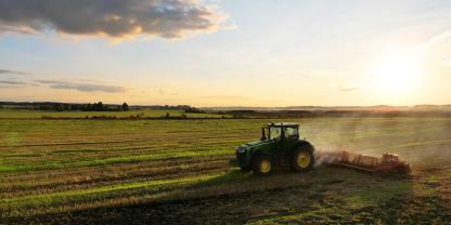 Ein Traktor auf einem Acker im Sonnenlicht