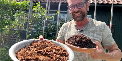 Mann mit zwei Schüsseln Mulch in der Hand