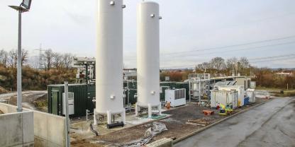Blick auf die gesamte Anlage, hinten rechts die Biogasaufbereitungsanlage, vorn die beiden Lagertürme für das verflüssigte Biogas und dahinter in den grünen Containern die Anlagenteile, die zur CO₂-Verflüssigung gehören.Blick auf die gesamte Anlage: hinten rechts die Biogasaufbereitungsanlage, vorn die beiden Lagertürme für das verflüssigte CO₂ und dahinter in den grünen Containern die CO₂-Verflüssigung.