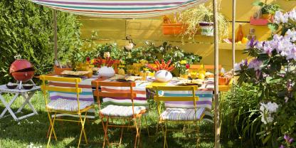 Bunt gestreiftes Tuch zwischen dünnen Holzstangen – fertig ist die einladende Schönwetter-Tafel.