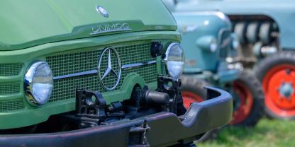 Ein grüner Unimog auf einer Wiese
