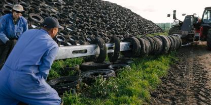Der 7 m lange Tyre Tosser wird mit Pkw-Reifen beladen. Bis zu 35 Reifen finden auf der Maschine Platz.