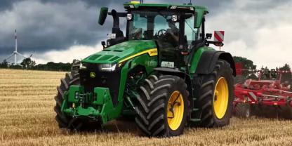 Ein John Deere mit Grubber auf einem Feld