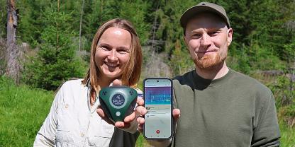 Martina Buchna, Rangerin im Nationalpark Bayerischer Wald, und Entwickler Dr. Stefan Kahl sind überzeugt von den Stärken der Tierstimmen-App BirdNET Live. Die Rangerin zeigt einen Audiologger, der über mehrere Tage im Wald hängen und Geräusche aufzeichnen kann. Mit diesem Gerät wurden Trainingsdaten für die App gesammelt.