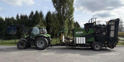 Ein Traktor mit Ballenpresse auf einem Parkplatz