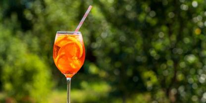 Orange im Glas, Eiswürfel und ein Platz in der Sonne: Aperol Spritz steht für unbeschwerten Genuss. Doch ganz so leicht ist seine Geschichte nicht.