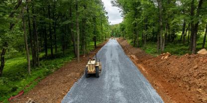 Eine Straße wird durch einen Wald gebaut