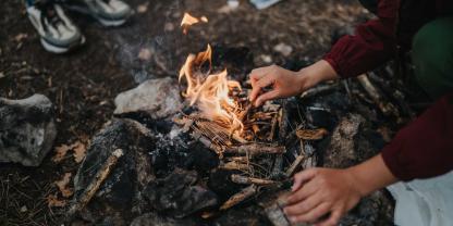 Auf dem Boden im Wald wird ein Lagerfeuer gemacht