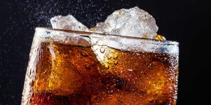 Ein Glas Cola mit Eis in Großaufnahme.