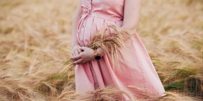 Ein Babybauch in einem Getreidefeld